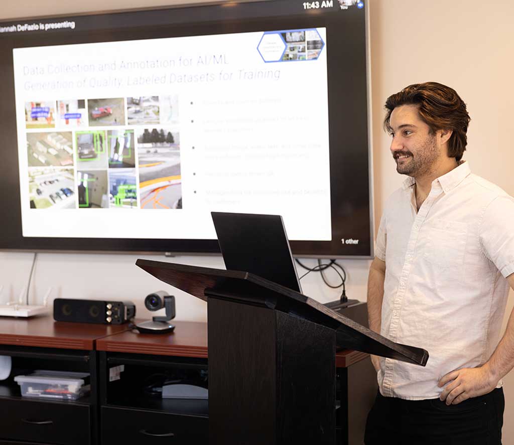 Instructor presenting slides at the front of a room.