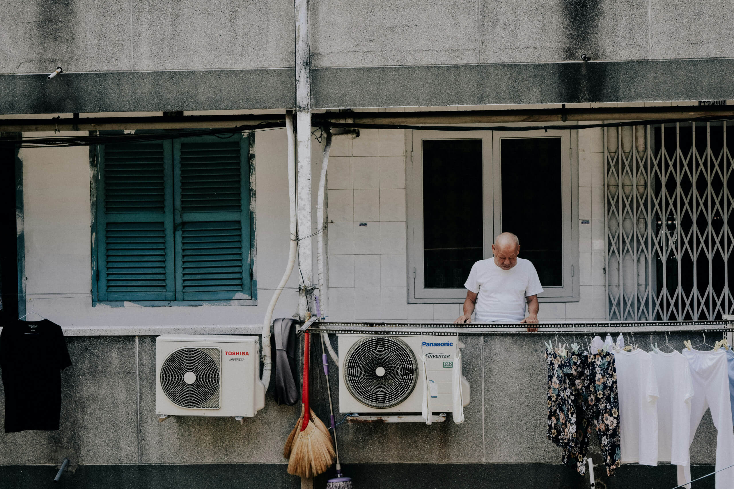 Ein Mann auf einem Balkon und Klimaanlagen