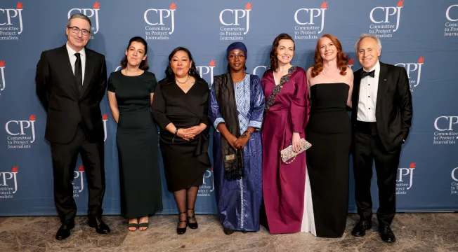 International Press Freedom Award honorees (beginning third from left) Quimy de Leon, Samira Sabou, and Alsu Kurmasheva, attend CPJ's IPFA event on November 21 in New York City, along with host John Oliver (left), Perrine Daubas (second from left), wife of Gwen Ifill Press Freedom awardee Christophe Deloire, CPJ CEO Jodie Ginsberg (second from right), and Board Chair Jacob Weisberg. Awardee Shrouq Al Aila was not allowed to leave Gaza to attend the event. (Photo: Dia Dipasupil/Getty Images)