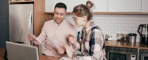 Couple in kitchen, looking at paperwork