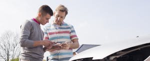 Two men exchanging insurance after a car accident