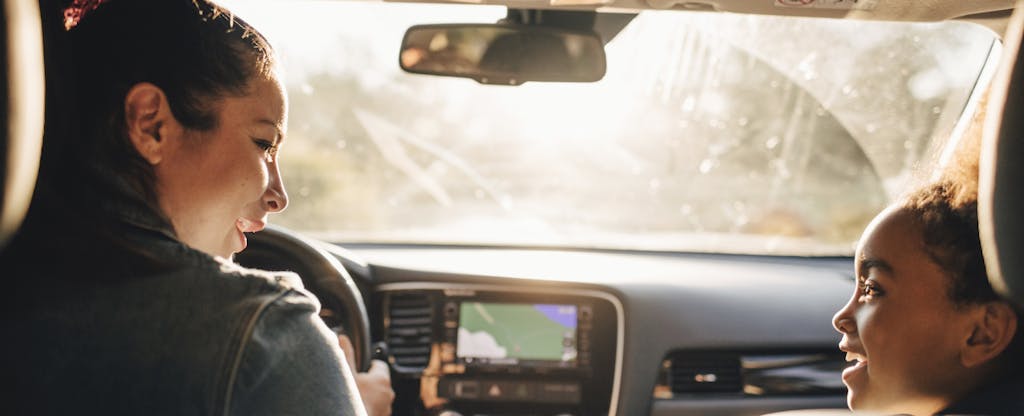 Woman with a usage-based insurance plan driving her daughter to school in the morning