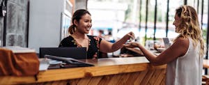 Receptionist handing over the keys to a hotel guest who just checked in