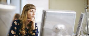 Young office worker in front of their computer, wondering about wage garnishment.