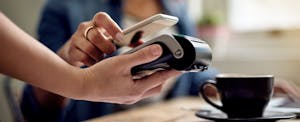 Closeup of somebody paying with Google Pay at checkout