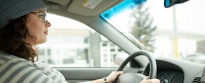 Woman driving her car with a serious expression on her face