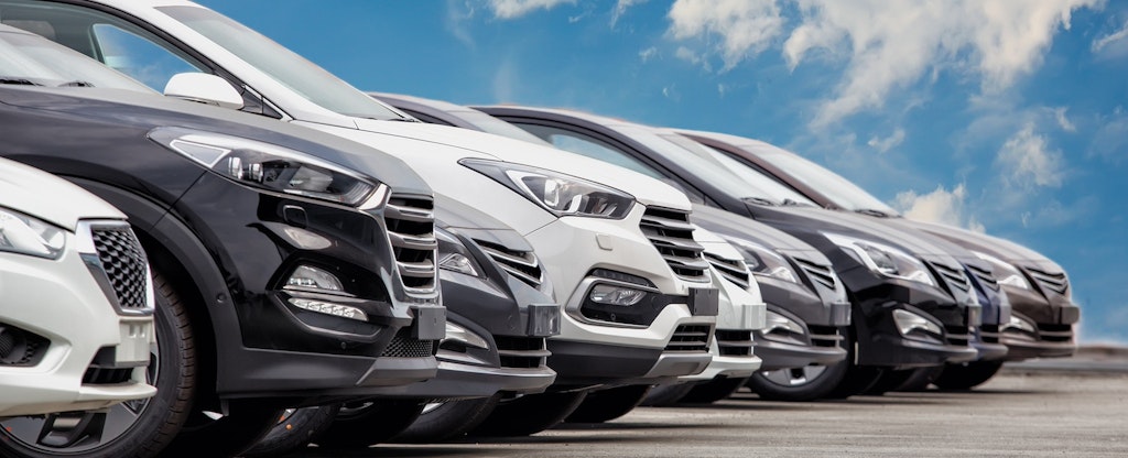 A row of cars under a blue sky.