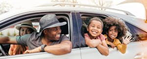 Happy family in car with windows down