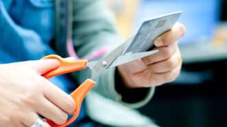 A woman cuts up a credit card | Photo 27246429 © Sixninepixels | Dreamstime.com