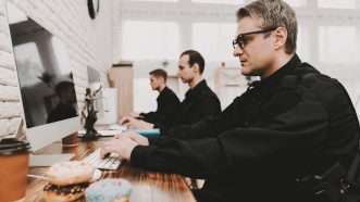 Officers in a police station work on computers. | Vadimgozhda | Dreamstime.com