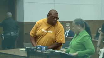 Corey Harris is seen in a shirt that says "Trust me" during a hearing in a Washtenaw County court | YouTube