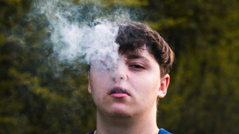 Male blowing vapor out of his face. | Photo by <a href="https://unsplash.com/@sebastianradu?utm_content=creditCopyText&utm_medium=referral&utm_source=unsplash">Sebastian Radu</a> on <a href="https://unsplash.com/photos/a-man-taking-a-selfie-GUsAFJL0FEo?utm_content=creditCopyText&utm_medium=referral&utm_source=unsplash">Unsplash</a>