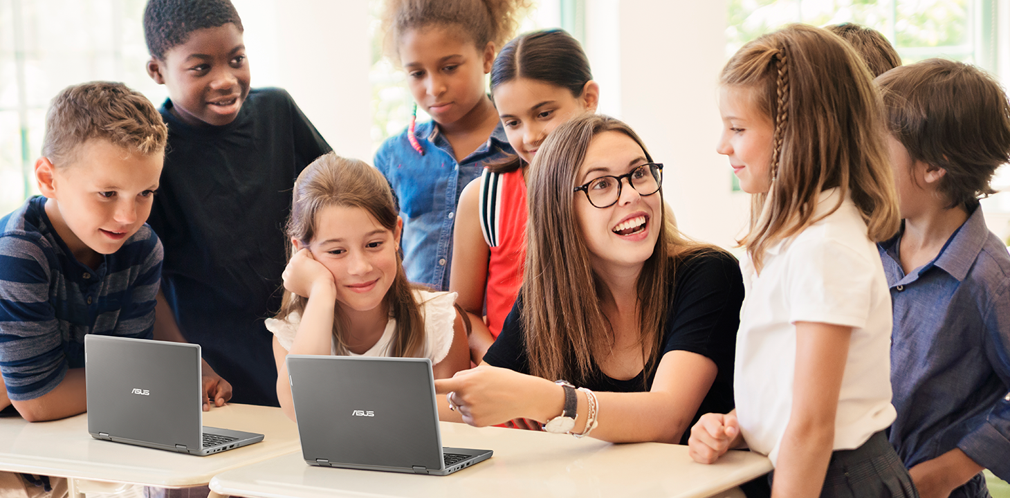 A teacher with K-12 students around, using ASUS BR1100 laptops in the classroom.