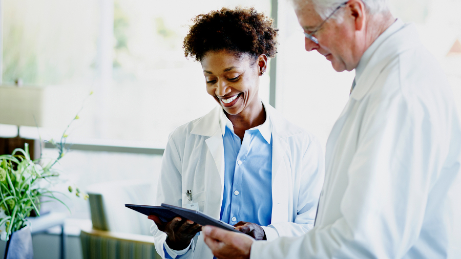 Two doctors are looking at their ASUS ExpertBook B3 detachable laptop with smile.