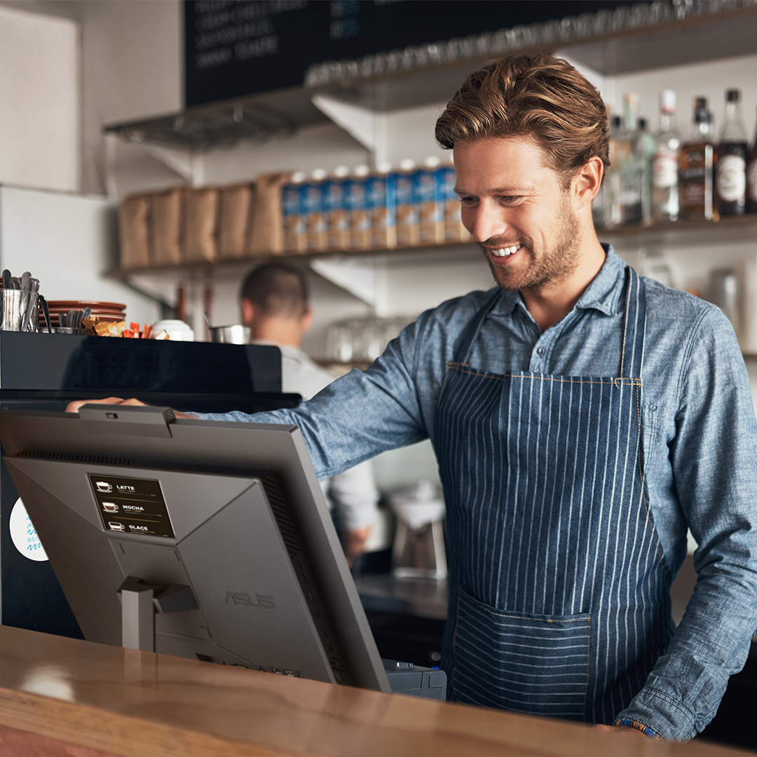 A coffee shop staff is using ASUS ExpertCenter E5 AiO at the front desk.