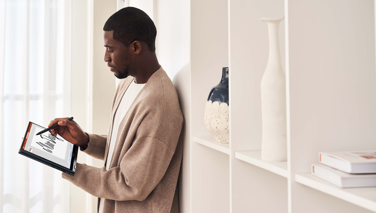 a man wearing light-colored clothes drawing on the screen of a Zenbook S 13 Flip OLED in tablet mode with an ASUS Pen 2.0 in his right hand