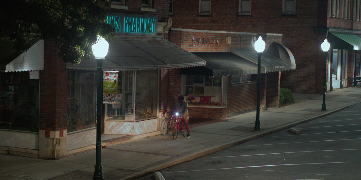 Pope pulls up to Guerin’s Pharmacy on his bike at night.