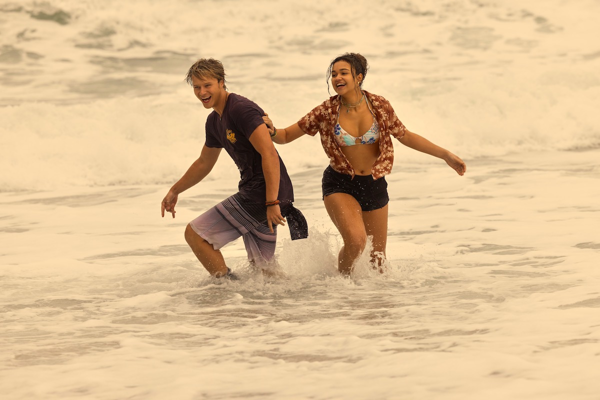 Rudy Pankow as JJ and Madison Bailey as Kiara standing in the ocean in ‘Outer Banks’ Season 4.