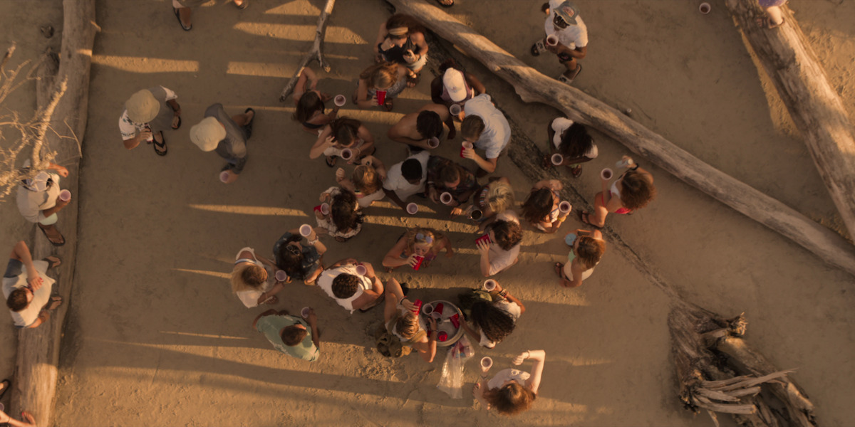 Bird's-eye view shot of the teens partying on a beach