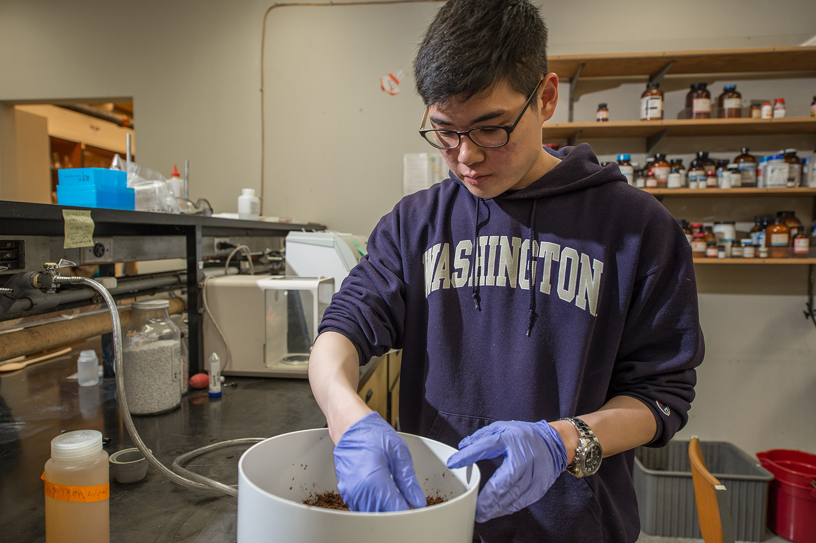 student lifting creature out of bucket