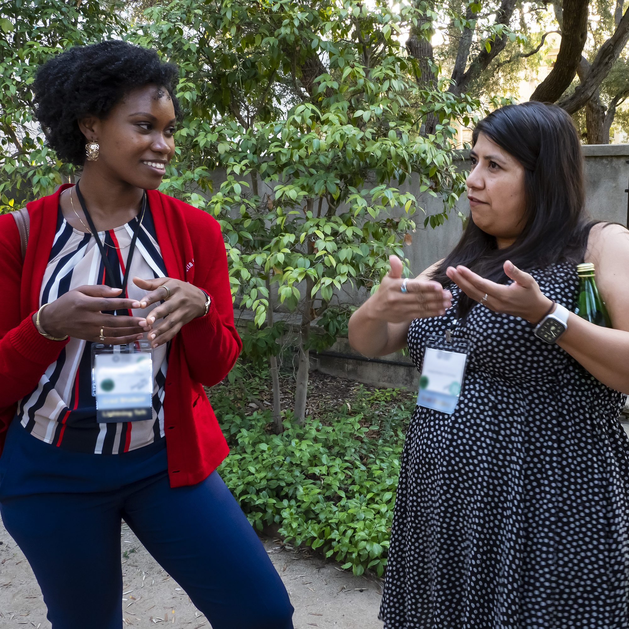 Two people stand outside talking at a conference.