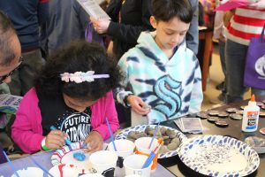 Two kids painting a pet rock they get to take home.