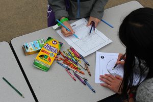 Kids coloring in Geoscience-themed coloring pages with colored pencils and crayons.