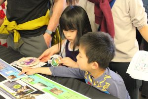 Two kids look at fossils at the Burke Museum table.