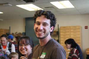 Close up of a student volunteer smiling with googley eyes on their face.