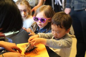 Two young kids stamping paper with a type of fault.