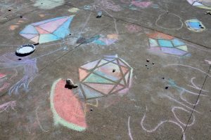 Chalk drawings of crystal shapes on concrete activity for participants.