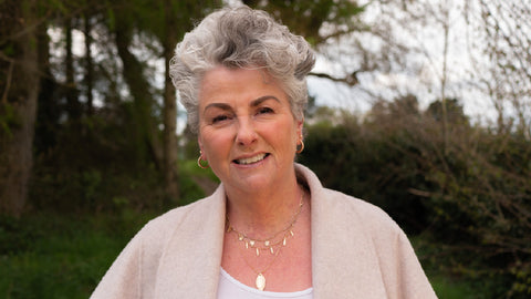 Photo showing Maxine Laceby, a smiling white woman with short grey hair, standing outdoors