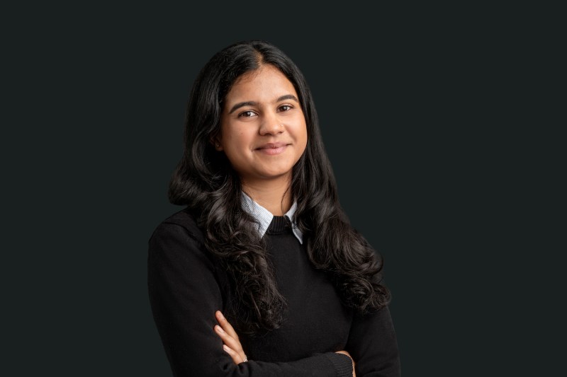 Anusha Rathi smiling for a professional headshot with her arms crossed.