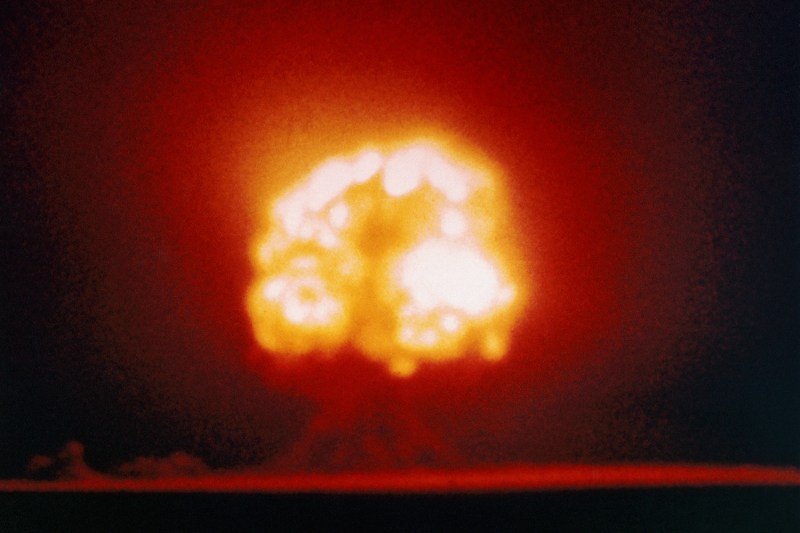 A giant orange mushroom cloud explodes on the horizon during the first atomic bomb test in New Mexico on July 16, 1945.