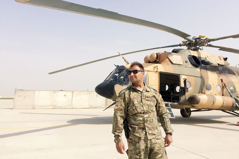 Ahmad Haidari in front of a helicopter at Kandahar International Airport.