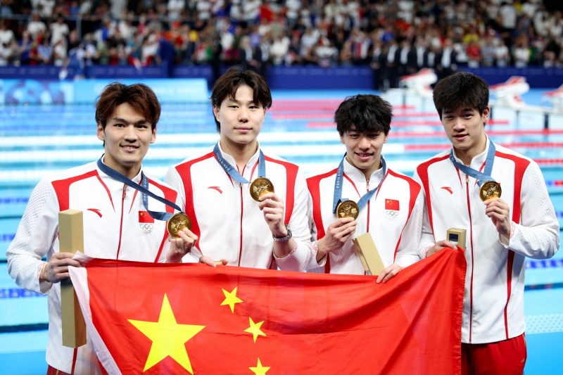 From left: Chinese swimmers Xu Jiayu, Qin Haiyang, Sun Jiajun, and Pan Zhanle pose after winning the men's 4x100m medley relay at Paris La Défense Arena in Nanterre, France, on Aug. 4.