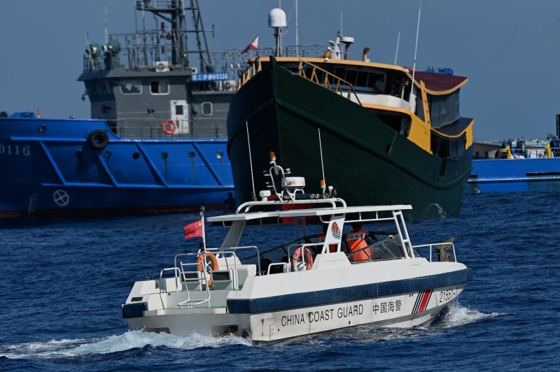 A Chinese Coast Guard patrol boat passes near the Philippine military chartered Unaizah May 4 during its resupply mission to the disputed Second Thomas Shoal in the South China Sea.