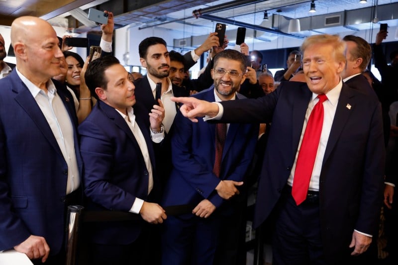 Donald Trump visits The Great Commoner cafe while Hamtramck mayor Amer Ghalib stands to his right on Nov. 1,  in Dearborn, Michigan.