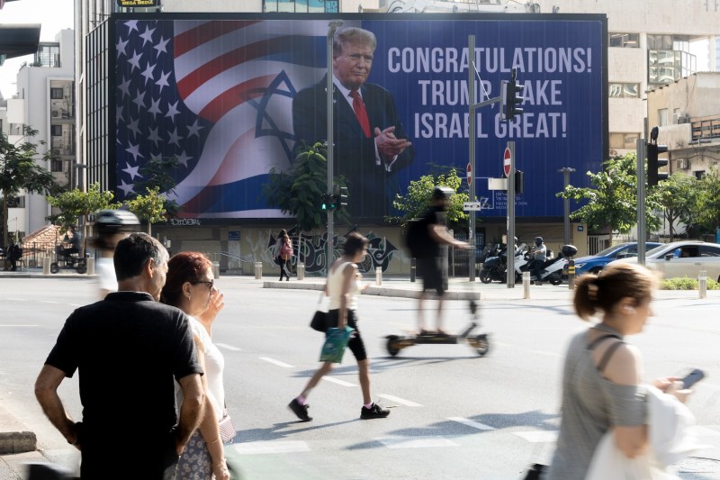 People pass by a congratulatory billboard showing U.S. President-elect Donald Trump in Tel Aviv, Israel, on Nov. 7.