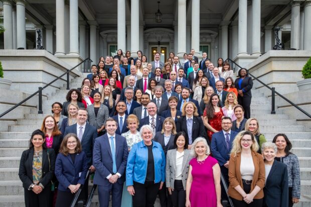 A large group of delegates from digital governments around the world pose on the ‘Navy Steps’ outside the Old Eisenhower Building, Washington DC.