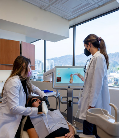 Dr Rhonda Kalasho checking her patient dental condition in computer screen along with her assitant