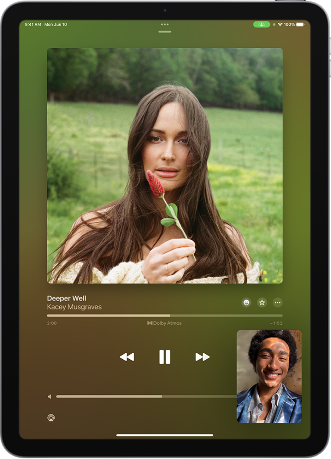 A FaceTime call showing a SharePlay session, with Apple Music content being shared in sync with everyone on the call. An image of the person sharing the content is shown at the bottom right, an image of the album being shared is near the top of the screen, and the playback controls are below the album image.