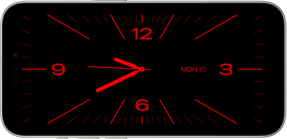 iPhone in Standby mode in low ambient light, displaying Clock and Calendar widgets with a red tint.