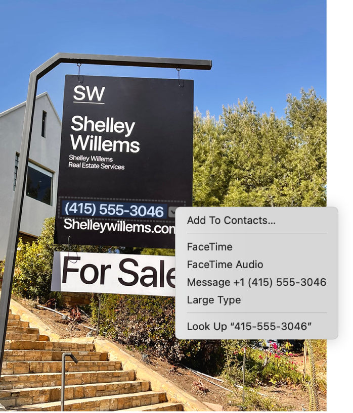 Photo of a Real Estate For Sale sign showing the agent’s phone number selected as Live Text and a menu presenting options to add the phone number to Contacts, call the number, start a FaceTime call, send a text message, and more.