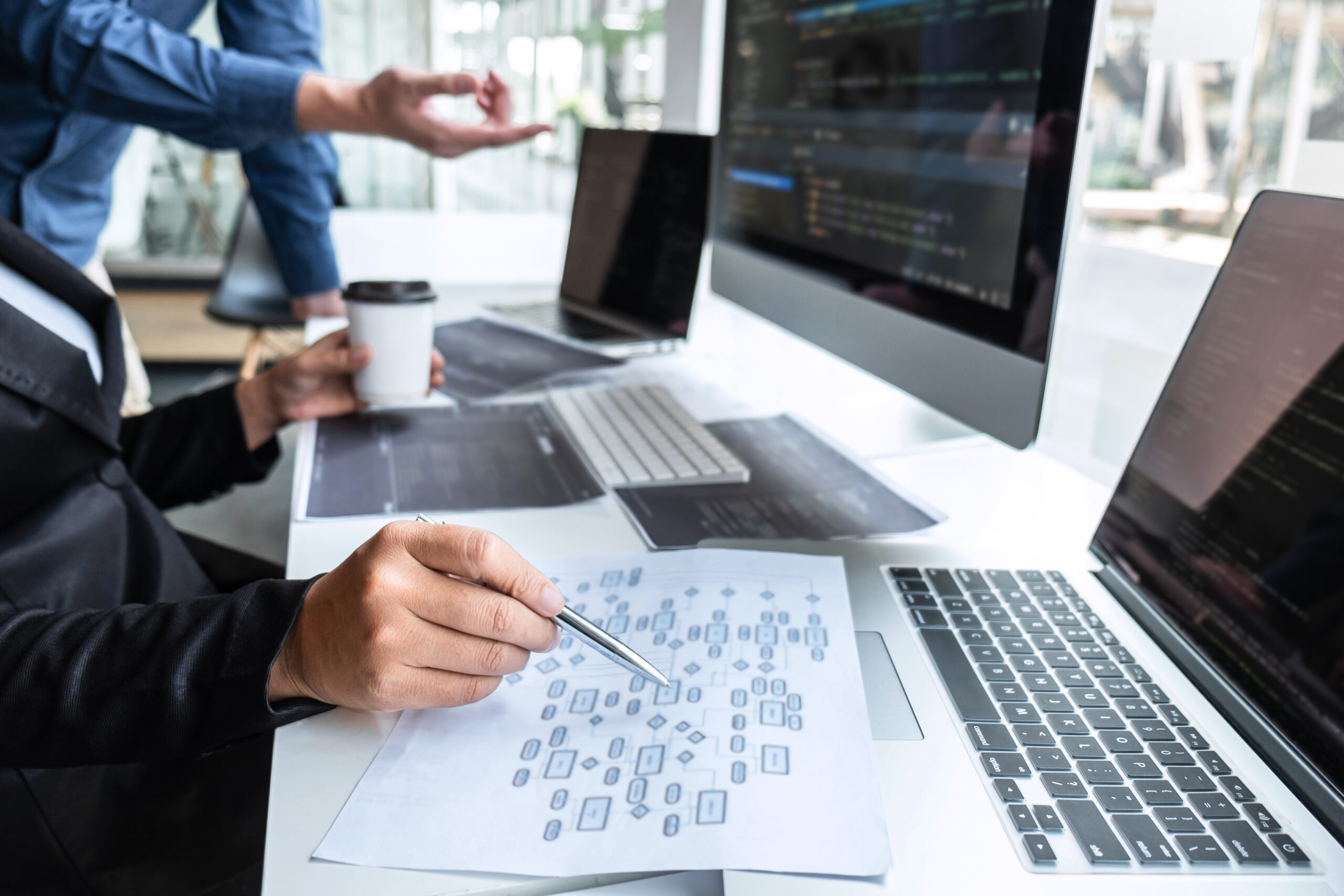 Person holding a coffee cup and analysing documents