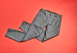 gray pants laid out on a solid red background