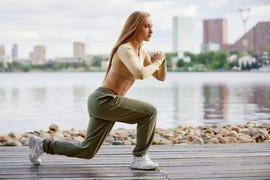 blonde young athletic woman working out in a park in an urban environment attractive athletic woman exercising outdoors in the morning, copy space health, fitness concept