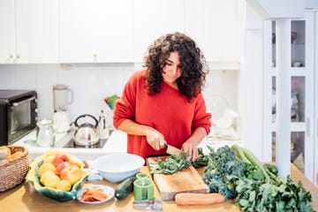 brunette woman making a healthy green salad