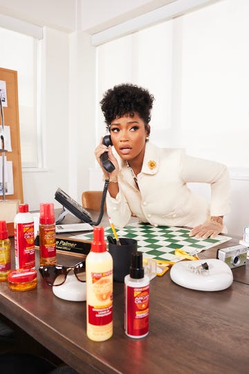 a desk setup features a woman leaning over a green checkered surface while talking on the phone