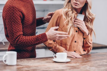 cropped shot of man quarreling with girlfriend holding smartphone in kitchen, distrust concept